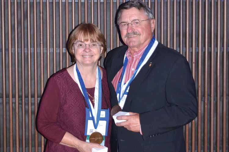 Two AVDC Presidental Medal of Stewardship winners stand holding their medals