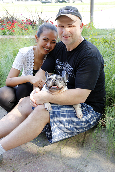 Man and woman holding French bulldog