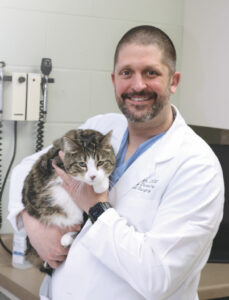 Clinical Professor Chris Snyder, who in June became associate dean for clinical affairs and teaching hospital director, holds Tiny, a patient of the UW Veterinary Care Dentistry and Oral Surgery Service, at a recheck appointment.