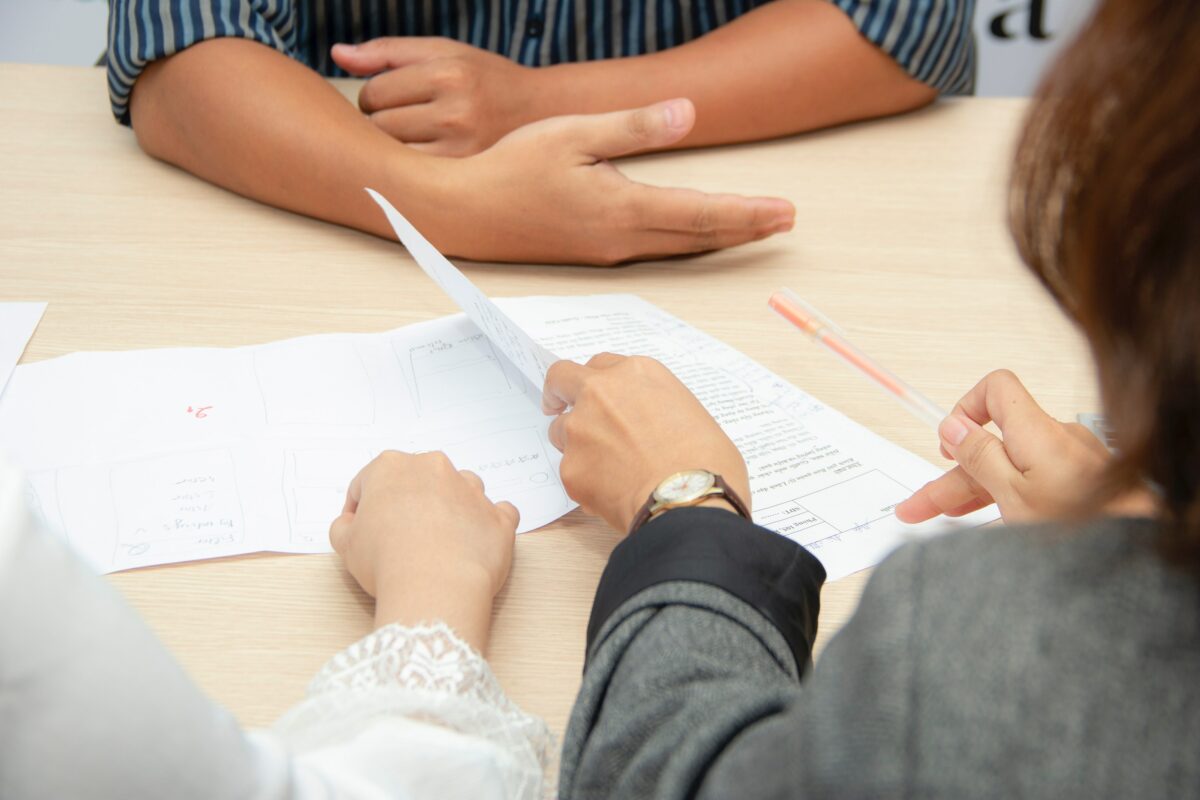 hands of people on table reviewing paperwork