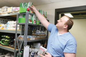 Kennel manager Jacob Jankowski retrieves pill pocket treats to aid clinicians in delivering medication to UW Veterinary Care patients