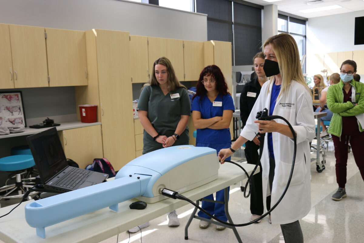 Clinical assistant professor Jessica Pritchard, right, demonstrates to students how to use a new endoscopy simulator to practice guiding an endoscope through internal organs.