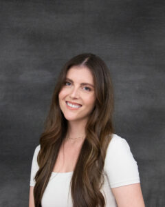A long brown hair woman wearing a white short sleeve top. Kiara Gilardi