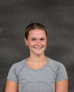 A pulled back brown hair woman wearing short sleeve gray shirt. Madeline Yokeley
