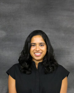 A long black wavy hair woman with dark navy top. Mira Seshan