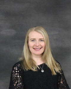 A long hair blonde woman wearing black texture sleeve top. Regina Sojka
